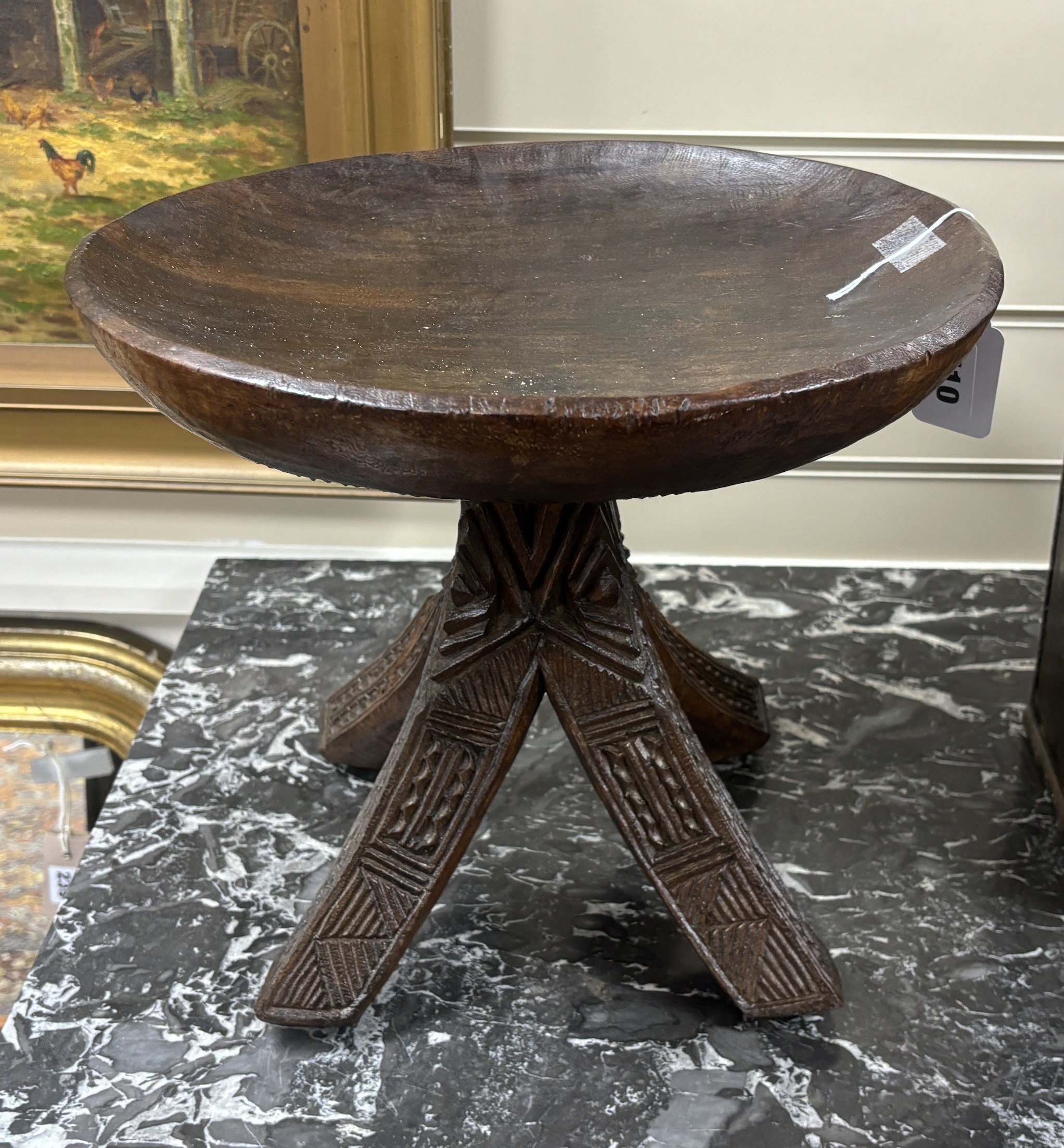 A carved African stool on four legs, 30cm high